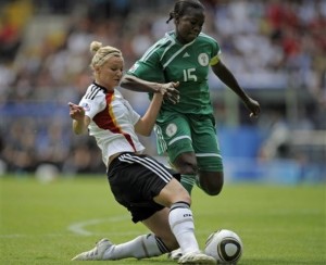 Germany's Alexandra Popp, left, scores the opening goal past Nigeria's Joy Jegede, right